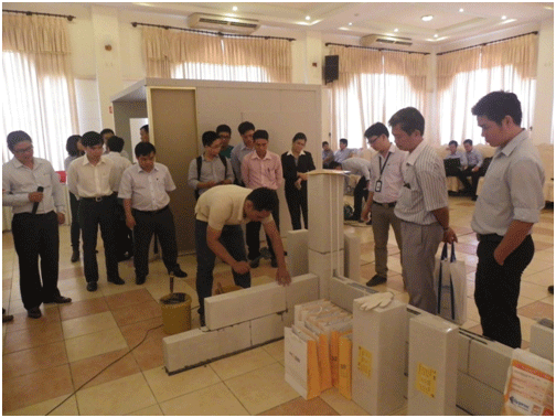 Các đại biểu tham khảo một điển hình xây dựng gạch bê tông khí chưng áp ACC, một loại vật liệu xây dựng mới đưa vào các công trình ở Việt Nam.