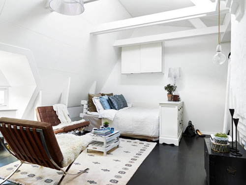   Căn hộ gác mái với nhiều nhược điểm như trần thấp, không vuông vắn được khắc phục với màu sơn trần, xà nhà, tường màu trắng.