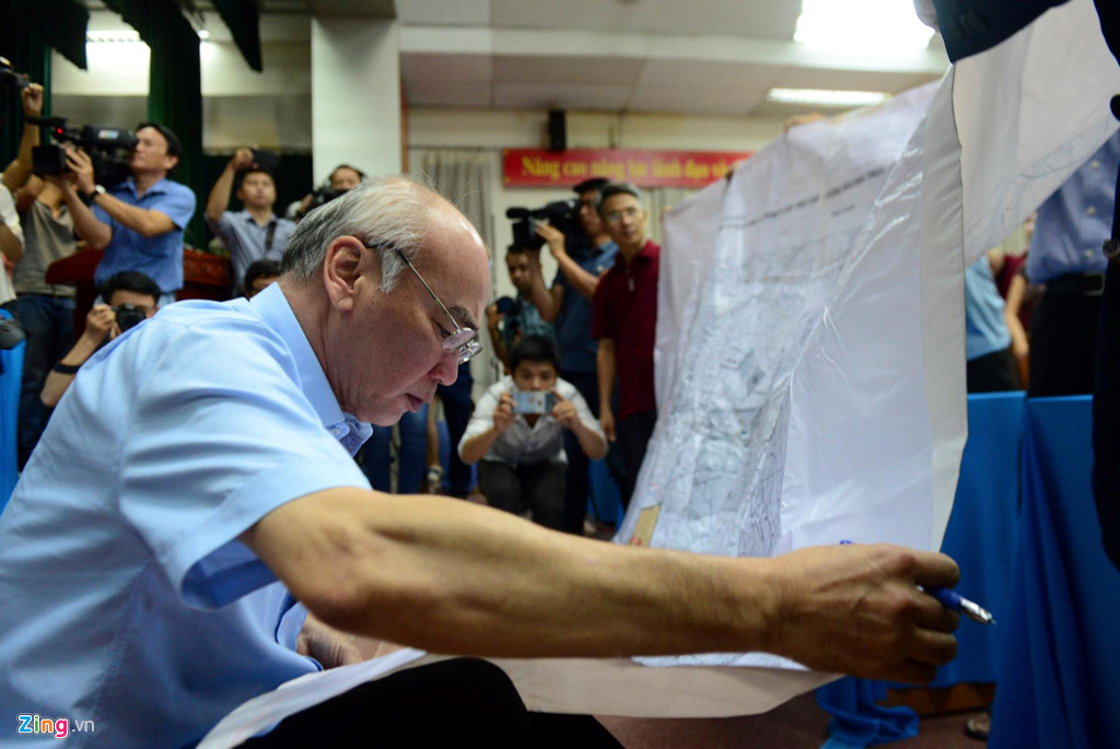 Ông Phan Nguyễn Như Khuê xem bản đồ Thủ Thiêm 1/10.000 do người dân trưng ra tại buổi tiếp xúc cử tri quận 2 vào ngày 9/5. Ảnh: Tùng Tin.