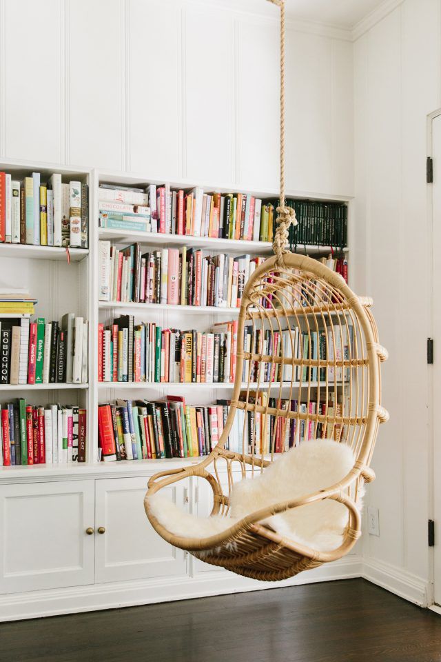 Một phong cách đầy ấn tượng cho không gian đọc sách với chiếc ghế treo, tủ sách chìm trong tường cùng màu sơn trắng tươi sáng.