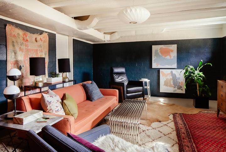 Phòng gia đình mang hai màu sắc chủ đạo xanh và cam hồng. Đồ nội thất trang trí cũng mang thiên hướng vuông vắn, điểm nhấn là tường và thảm trải sàn. 
