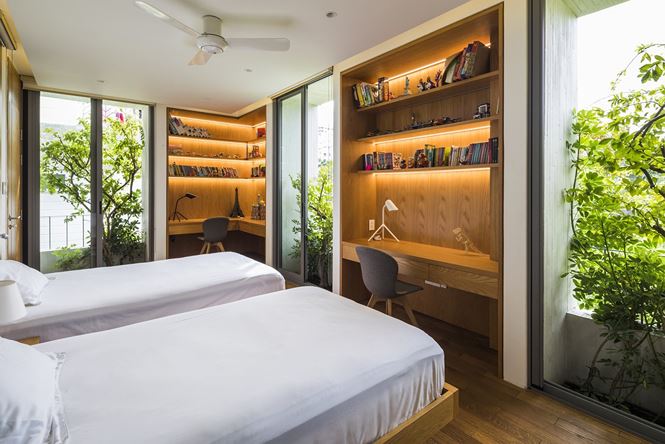 Phòng ngủ được thiết kế tinh tế với hai khu vực bàn học riêng biệt nhưng vẫn có sự gắn kết với cây cối