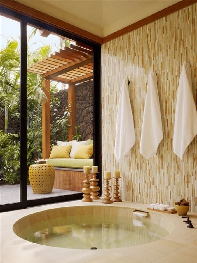 Phòng tắm nhiệt đới với gam màu trung tính với bồn tắm chìm và cửa trượt ra vườn để ngắm cảnh và đón nắng