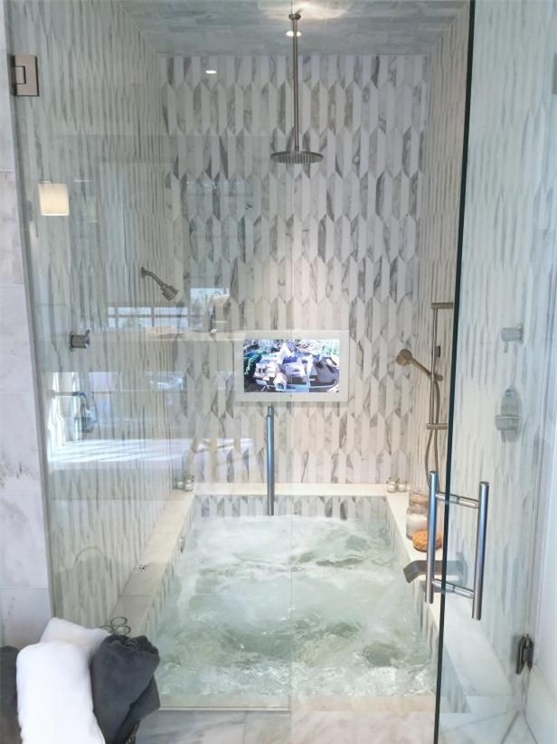 Bồn tắm chìm kết hợp với không gian tắm và ốp bằng gạch trung tính và bắt mắt rất thoải mái, tiết kiệm không gian