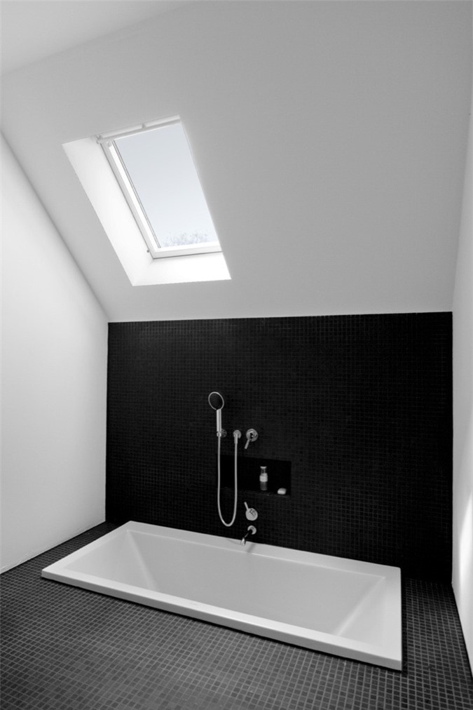 Phòng tắm đơn sắc tối thiểu với hai màu đen và trắng, có giếng trời và bồn tắm chìm là một không gian rất đơn giản và phong cách