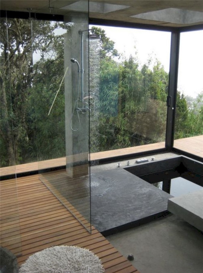 Phòng tắm tối giản với sàn gỗ, không gian tắm bê tông và bồn tắm chìm cùng với tầm nhìn toàn cảnh