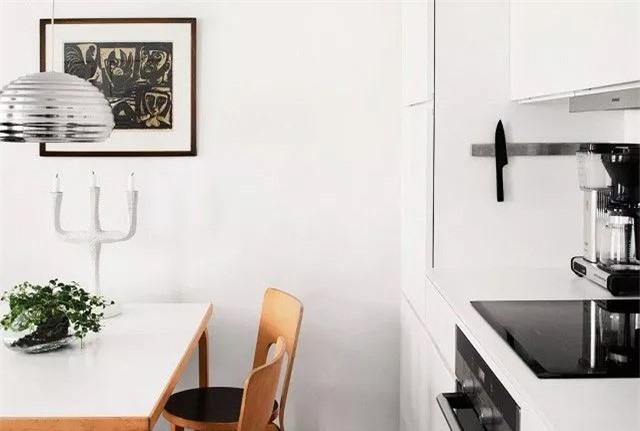 Nhà bếp đầy cá tính với việc bổ sung một vài phụ kiện độc đáo như đèn mặt dây chuyền, nến dân gian và linocut tượng hình trong nhà bếp Scandinavia này.