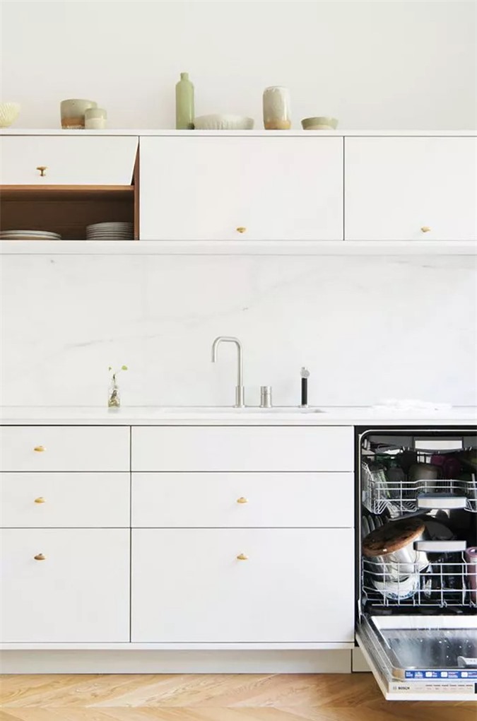 Hầu như không đủ chỗ để quay vòng trong căn bếp nhỏ bé này, nhưng nhà thiết kế đã làm một công việc tuyệt vời để ngăn chặn cảm giác ngột ngạt bằng cách sử dụng tủ hiện đại, sạch sẽ và bảng màu trắng.
