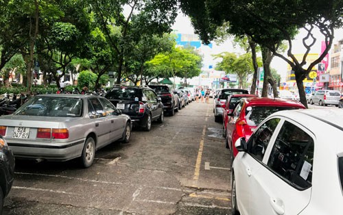 Công viên Lê Văn Tám (quận 1, TP HCM) - nơi vừa hủy dự án xây dựng bãi đậu xe - đang tận dụng một phần làm bãi đậu ôtô do nhu cầu lớn Ảnh: GIA MINH