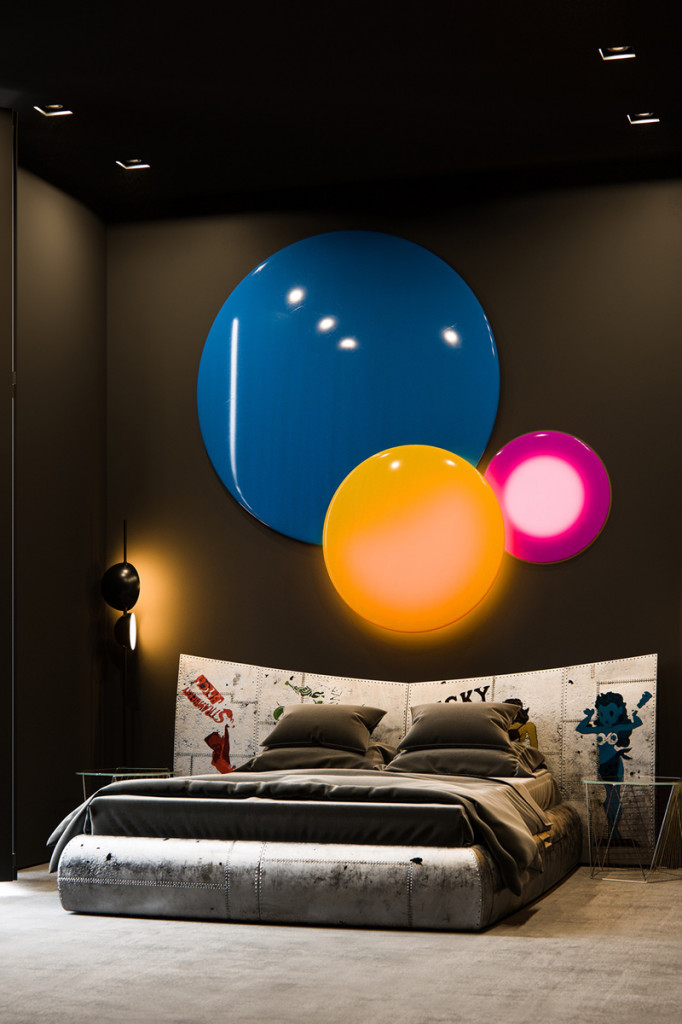 Phòng ngủ bao gồm đèn tường, giường ngủ, tranh dán đầu giường mang phong cách của một ngôi sao