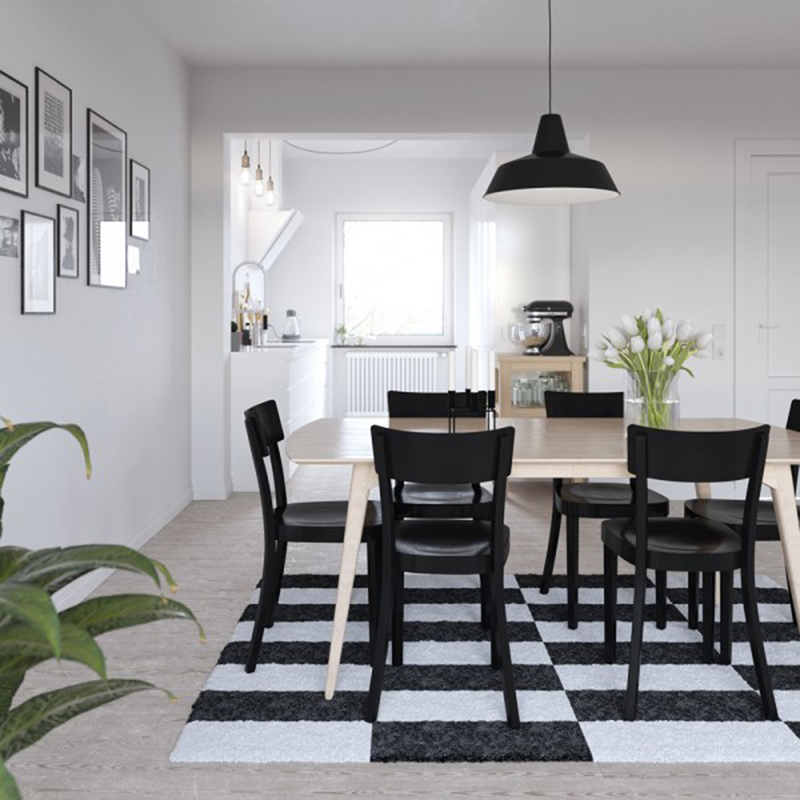 Phòng ăn này có nét độc đáo gồm những chiếc ghế màu đen được đặt trên tấm thảm có ô màu trắng-đen đan xen.