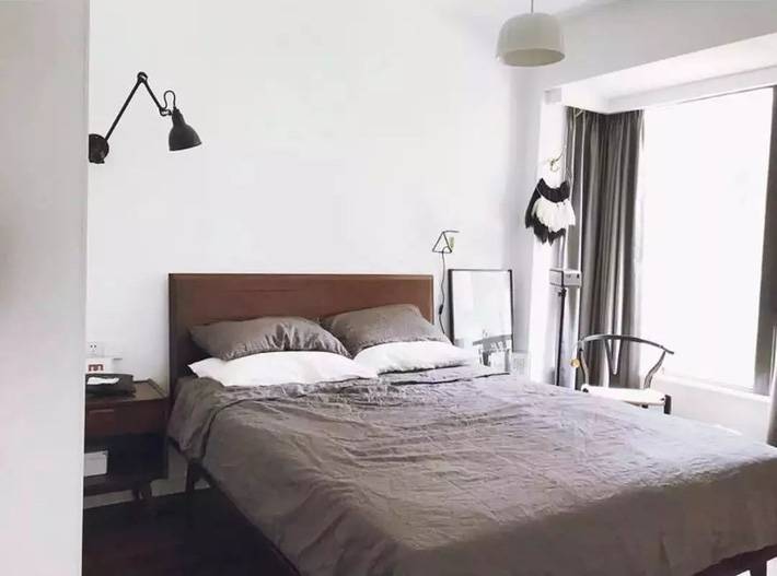 Không gian phòng ngủ đơn giản, màu ga gối cùng màu xám với màu rèm cửa