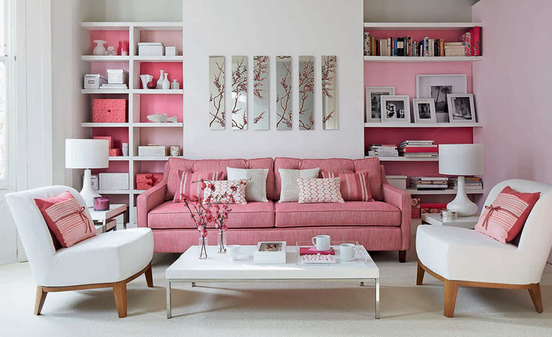 Nếu phòng khách chỉ độc một màu trắng nó sẽ trở nên nhàm chán. Vậy nên kệ sách và ghế sofa màu hồng khiến căn phòng trở nên trẻ trung và sinh động hơn.
