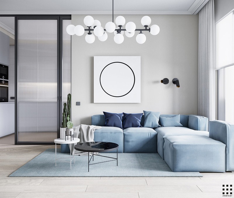 Bước vào phòng khách bạn sẽ ngạc nhiên trước vẻ đẹp nhẹ nhàng của ghế sofa màu xanh pastel. Ghế ôm trọn một tấm thảm màu xanh, bàn nước cùng đèn chùm độc đáo bên trên.