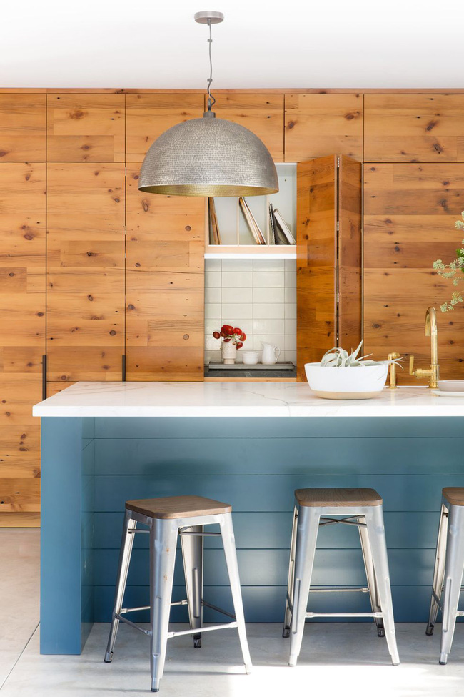 Trong nhà bếp này của Regan Baker Design, mặt tiền gỗ từ sàn đến trần che giấu các tủ và mặt bàn