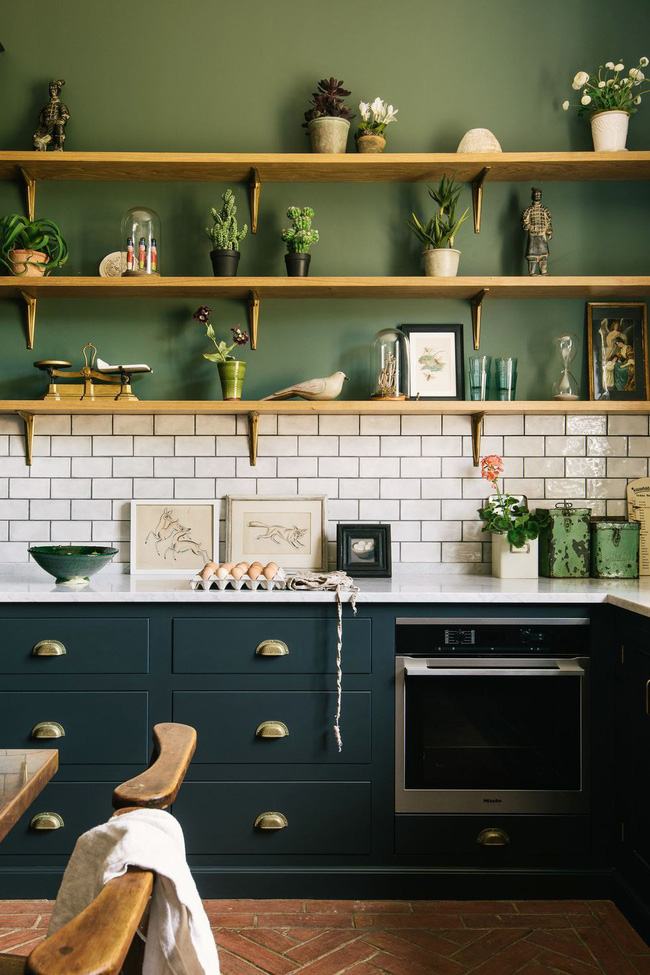 Trong không gian này được thiết kế bởi nhà bếp deVol, các tủ bếp thấp màu xanh ngọc trở nên sâu thăm thẳm. Giữa chúng, gạch trang trí có cảm giác như một sự bổ sung tự nhiên, nhờ vào đường vân vữa màu xanh đậm thay vì màu trắng cổ điển
