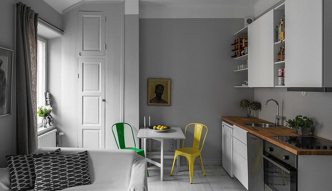 Nhà bếp đơn sắc với ghế đầy màu sắc cho khu vực ăn sáng