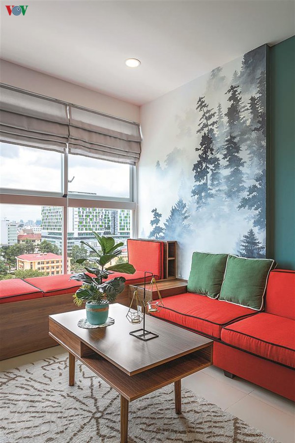 Hình ảnh rừng thông được tái hiện trong phòng khách. Để cân bằng màu sắc bộ sofa có màu đỏ nổi bật trên nền xanh.