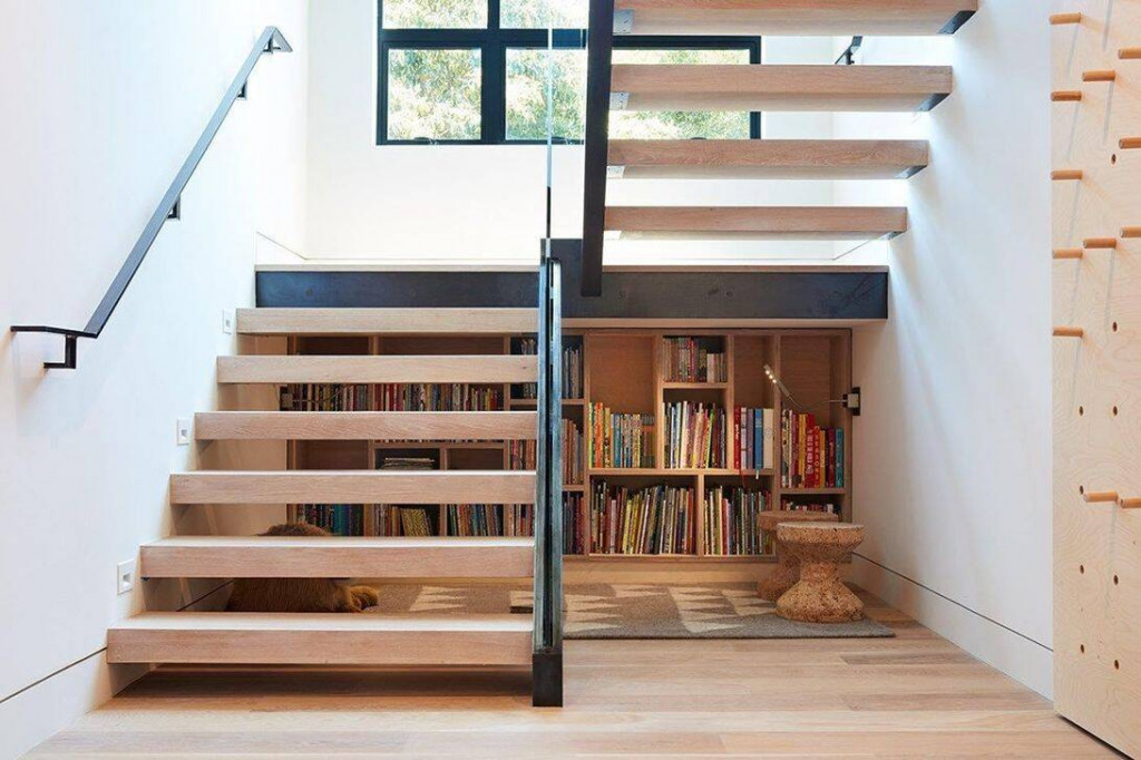 Tủ sách ngay dưới gầm cầu thang giúp các thành viên có thể tiếp cận sách bất cứ lúc nào