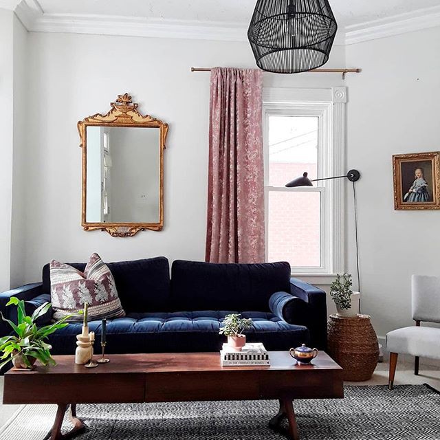 Sofa nhung màu xanh tím với phần gối cuộn hình tròn, có thể dựa lưng hoặc gối đầu
