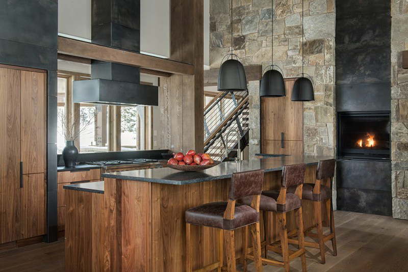 Căn phòng bếp gỗ mang hơi hướng rustic với tường đá, đèn trang trí kim loại, bàn đá cẩm thạch ấn tượng