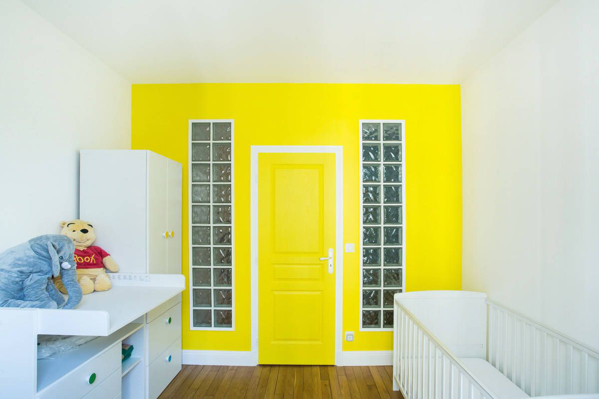 Tường và cửa chính màu vàng tạo điểm nhấn màu sắc cực mạnh cho căn phòng theo phong cách Paris đương đại này