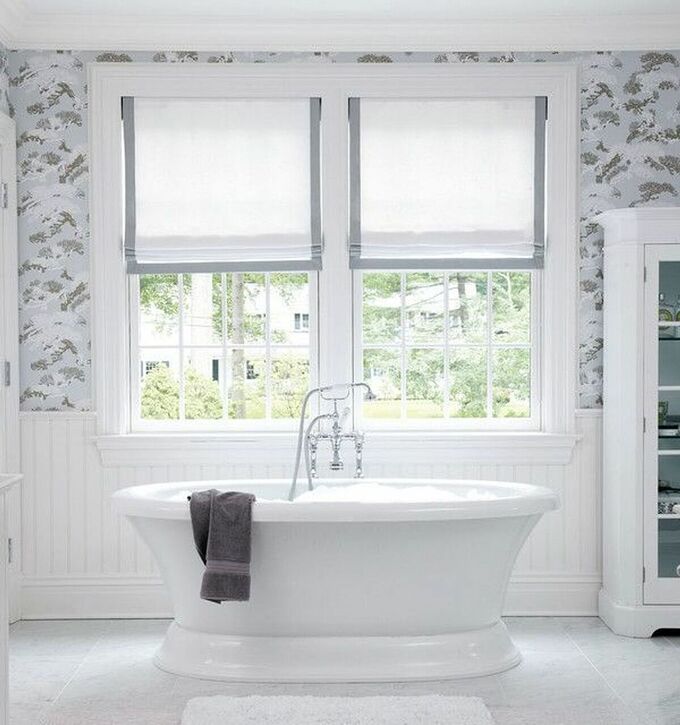 Phòng tắm hiện đại này sử dụng cửa sổ khung cửa màu trắng, bồn tắm cùng tông màu đặt cạnh cửa sổ giúp không gian sang trọng.