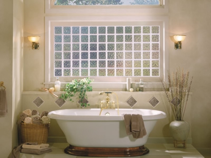 Tông màu tường vàng nhạt giúp không gian tắm ấm áp. Cửa sổ kính mờ mang đến sự riêng tư đồng thời giúp đón ánh nắng vào ban ngày, giúp phòng tắm khô thoáng. Trong phòng, đèn treo tường, vòi nước màu vàng tạo điểm nhấn cho không gian.