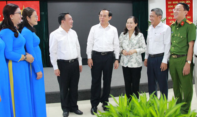 Bí thư Trung ương Ðảng, Bí thư Thành ủy TP HCM Nguyễn Văn Nên (giữa) và Chủ tịch HÐND TP Nguyễn Thị Lệ (thứ 3 từ phải sang) trao đổi với lãnh đạo quận 3