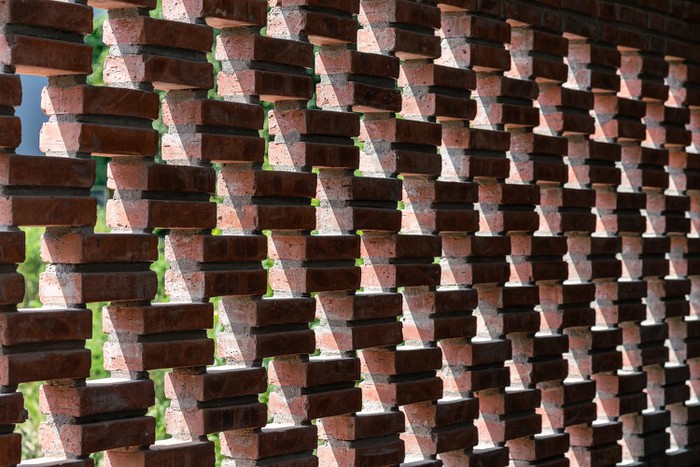 Tường gạch không trát được sắp xếp khéo léo để tạo ra các khe hở vừa đủ cho nắng gió tự nhiên chan hòa khắp không gian nhà