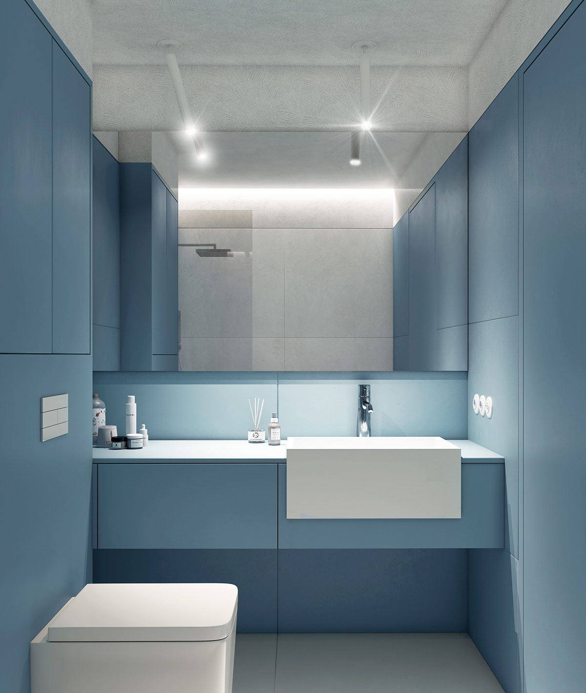 Chủ đề màu xanh lam tuyệt đẹp trở lại bên trong phòng tắm nhỏ, với những bức tường màu xanh lam kiên cố và tủ đồ.