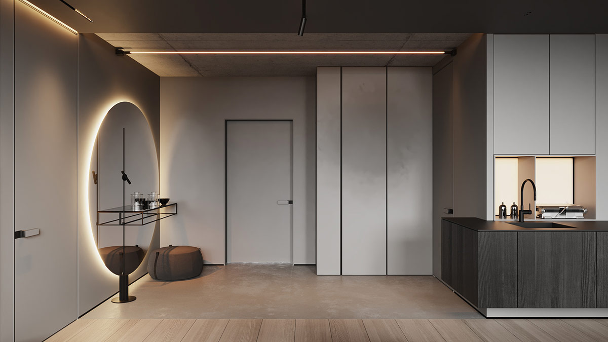 Một thiết bị chiếu sáng tuyến tính phía trên một lối vào nhà bằng bê tông. Tủ quần áo màu xám ở hành lang kết hợp liền mạch với nhau thành một thiết kế nhà bếp màu xám