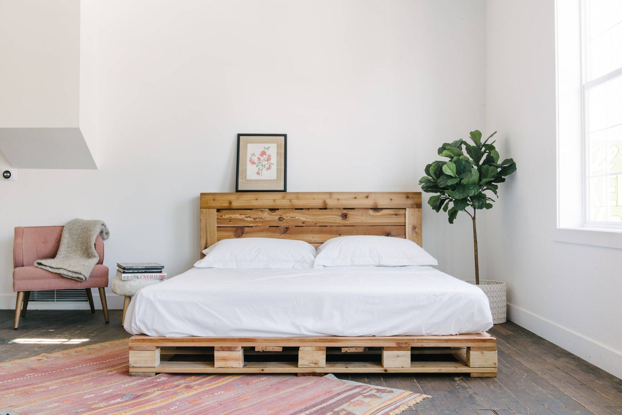 Phòng ngủ tối giản với giường pallet và ghế tạo điểm nhấn