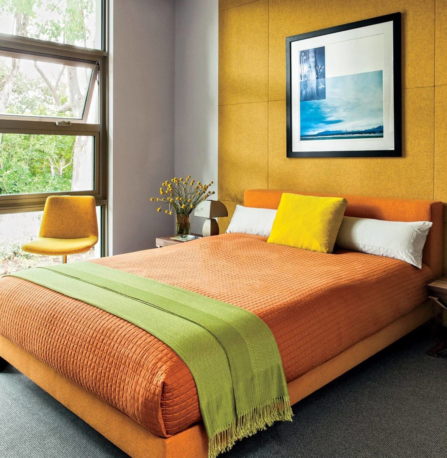 Bức tường nổi bật với tông màu mù tạt bằng vải được tô điểm bởi bộ khăn trải giường bằng vải thô, ghế màu vàng và khung giường đầy màu sắc trong phòng ngủ màu sắc rực rỡ này. Thiết kế của căn phòng được tối giản hóa thành công khi sử dụng tông màu vàng và sáng để mang lại sức sống cho khu vực.