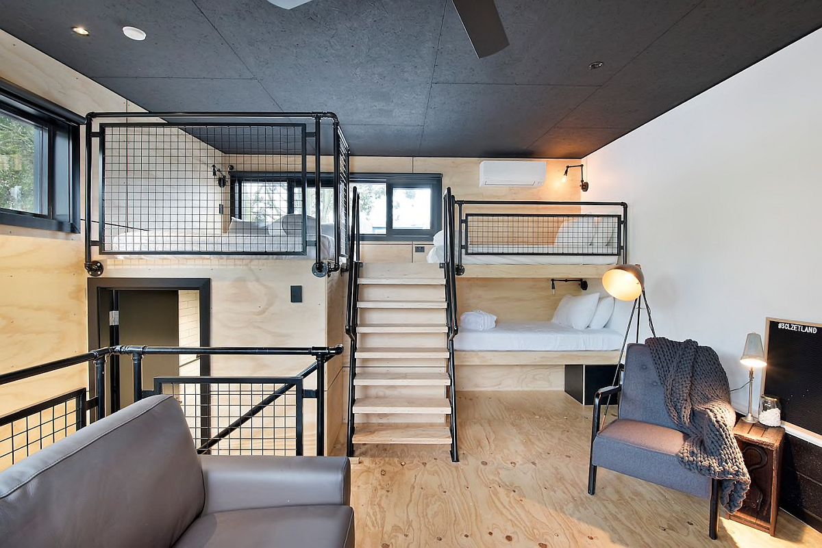 Phòng ngủ công nghiệp hiện đại trên tầng áp mái bằng gỗ và màu đen với lối trang trí thông minh