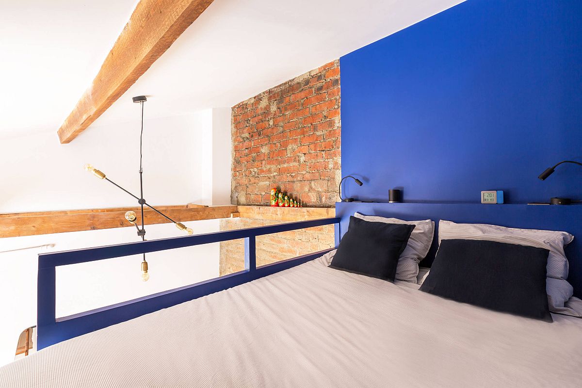Phòng ngủ công nghiệp nhỏ nhắn với bức tường nổi bật màu xanh lam và thiết kế siêu phong cách