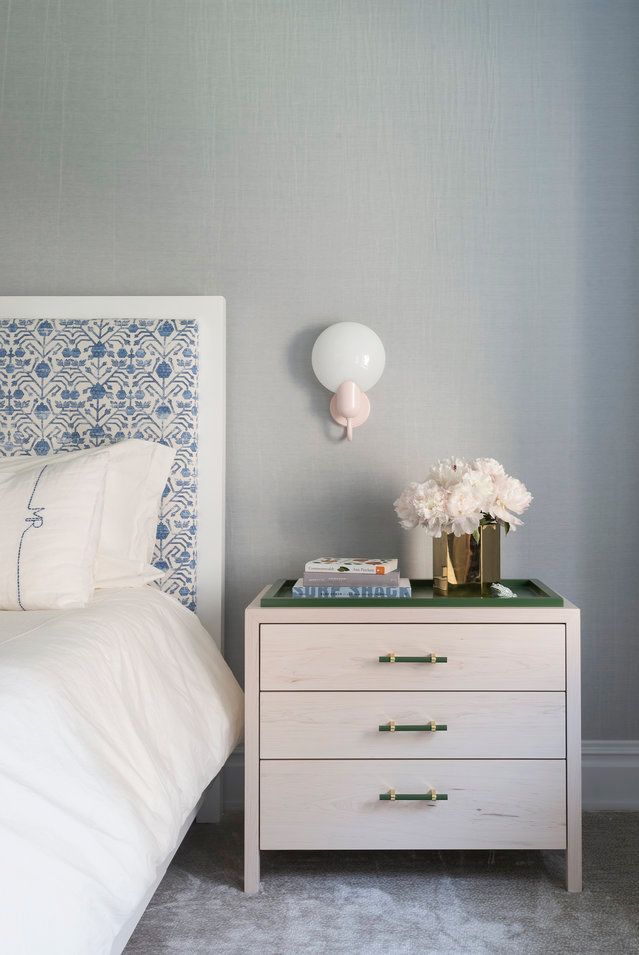 Một chiếc đèn treo tường màu hồng baby và đầu giường bọc nệm màu xanh lam tạo thêm chút ngọt ngào cho các yếu tố màu xanh lá cây và xám xuyên suốt.