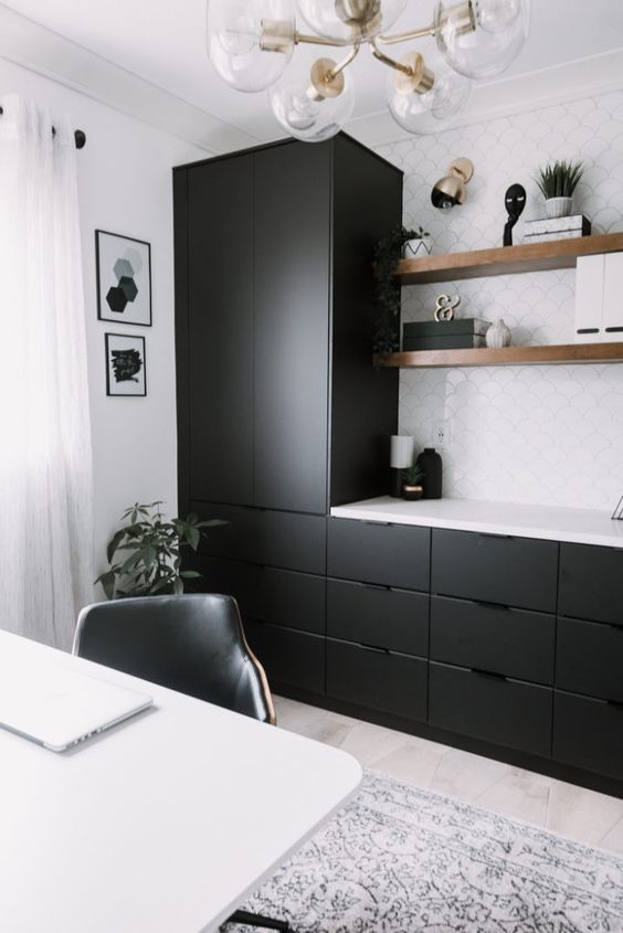 Không gian làm việc tại nhà hiện đại với tủ đen kiểu dáng đẹp và gạch nền trắng, kệ nổi và bàn làm việc màu trắng cộng với đèn chùm cổ điển