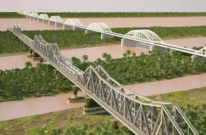 ĐSĐT trên cao đi bên cạnh ĐSQG, cả hai tuyến đường sắt vẫn cản trở đường bộ trong phố và không hỗ trợ bảo tồn cầu Long Biên. Nguồn : HanoidataST&BT