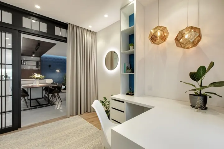 Bàn làm việc tích hợp thêm tủ lưu trữ, đèn treo nghệ thuật giúp không gian không bị rơi vào cảm giác nhàm chán