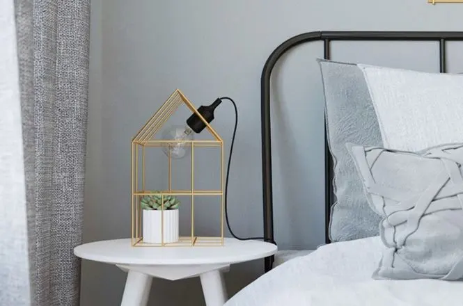 Đèn đầu giường được lồng vào khung sắt nơi chủ nhân còn trang trí thêm một chậu cây xinh xắn bên trong