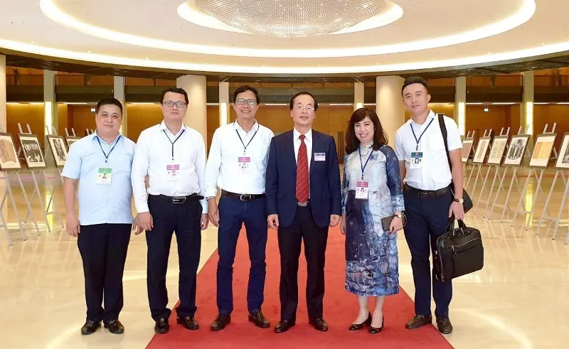 Bộ trưởng Bộ Xây dựng Phạm Hồng Hà chụp ảnh cùng Ban soạn thảo Luật Kiến trúc bên hành lang Quốc hội