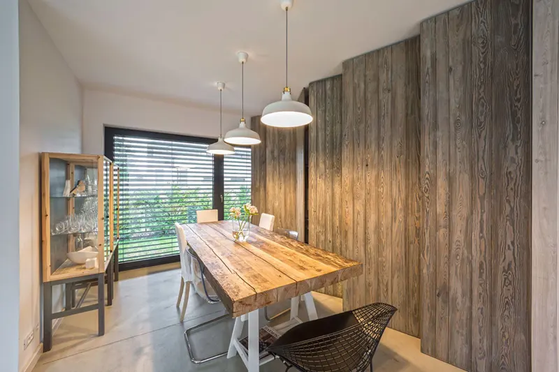 Ba chiếc đèn mặt dây chuyền đơn giản, chiếu sáng cho chiếc bàn gỗ. Chân bàn sơn trắng tạo sự phá cách độc đáo cho khu vực phòng ăn.