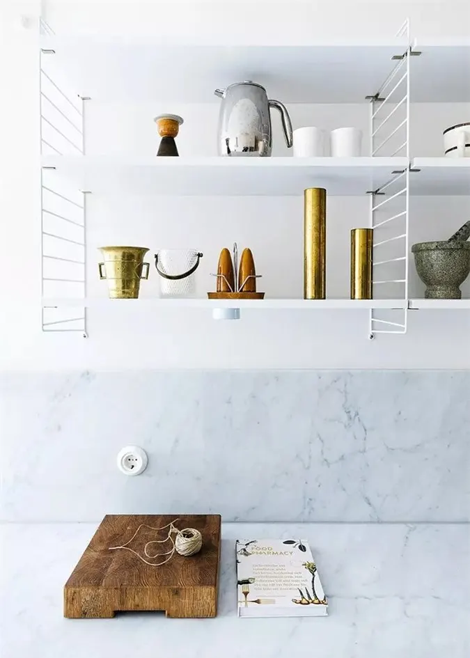 Một kệ ngắn chứa cốc cà phê hàng ngày và khối nhỏ cung cấp nơi trú ẩn để đựng bát đĩa. Với hầu hết tất cả các tủ được đặt bên dưới quầy và chỉ là những mảnh đẹp nhất được trưng bày, không gian trở nên thoáng đãng, không lộn xộn.