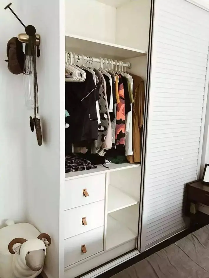 Một chiếc tủ đựng đồ màu trắng ngăn nắp được đặt trong phòng ngủ