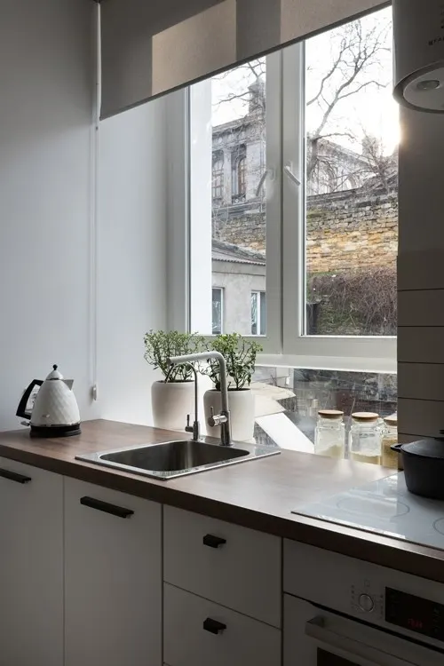 Bậu cửa sổ nằm sau bàn bếp là nơi đặt lọ gia vị và trồng các cây thảo mộc.  