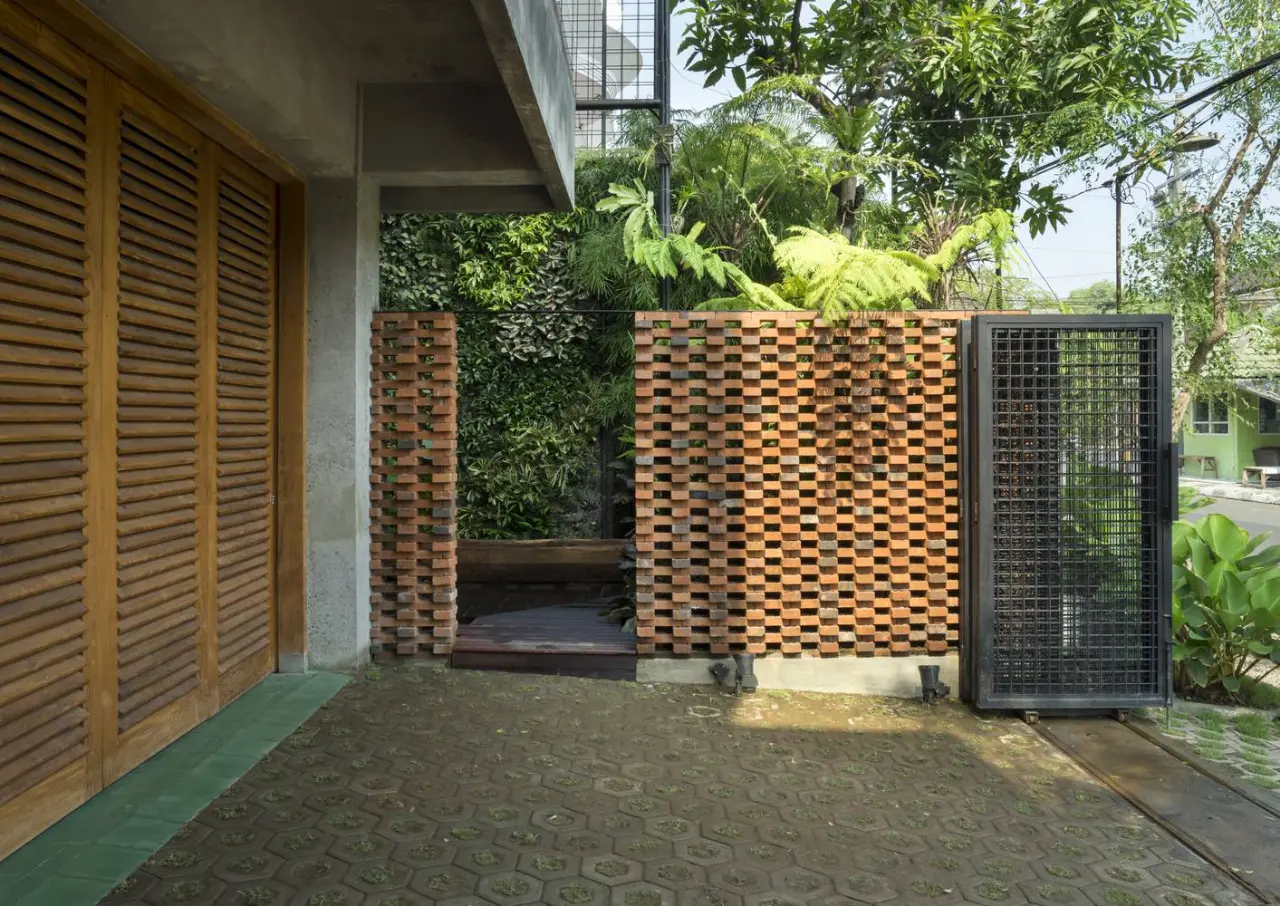 Cổng của căn nhà gạch rất mộc mạc nhưng không kém phần tinh tế với bức tường gạch xếp chồng
