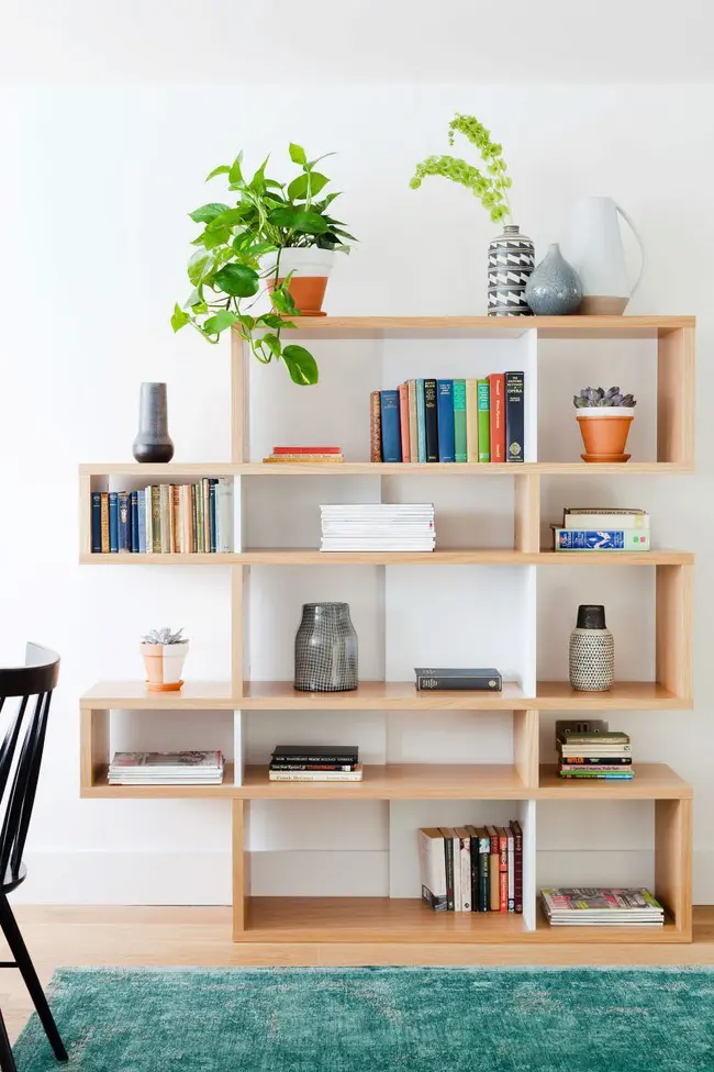 Giá sách với hình khối mở không đối xứng đem lại cảm giác bí ẩn cho bức tường trống