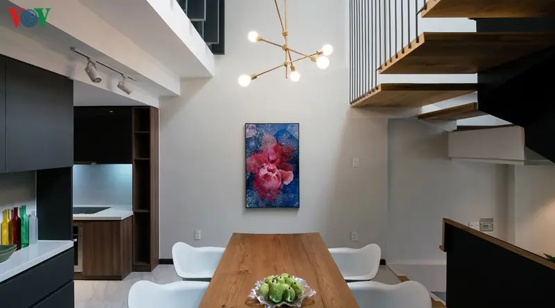 Bếp và phòng ăn nằm ở trung tâm ngôi nhà. Phía trên bàn ăn là một khoảng thông tầng đem lại sự thoáng đãng.