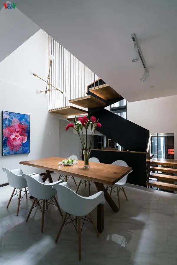 Cầu thang được thiết kế như một khối điêu khắc là điểm nhấn trong không gian. Lan can cầu thang là những mảng thép sơn màu xám sẫm.